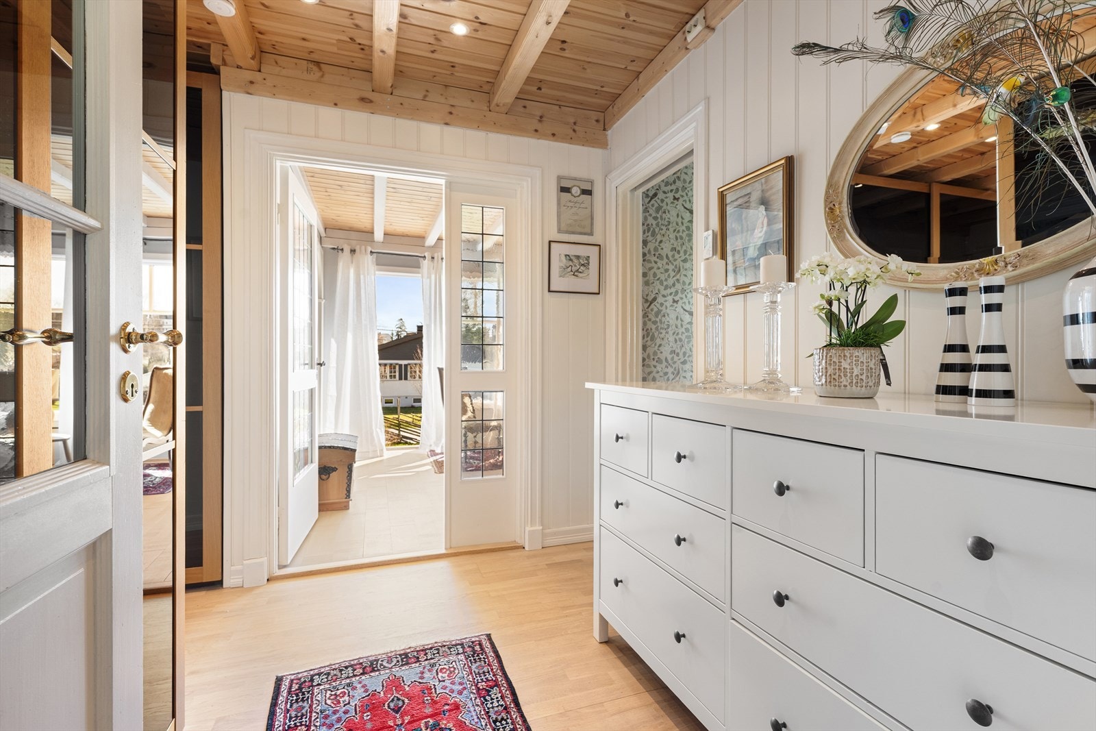 Fra gangen åpner boligen seg opp, med dør med glassfelt inn mot stuen som sikrer en lys og åpen romfølelse. Galleribilde