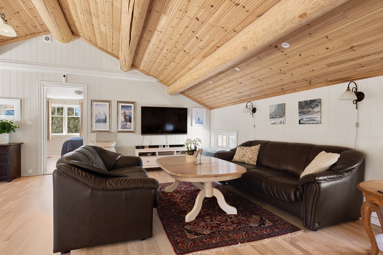 Loftstuen har en imponerende mønehøyde på 3,05 meter, med synlige bjelker og trepanel i himlingen. Galleribilde