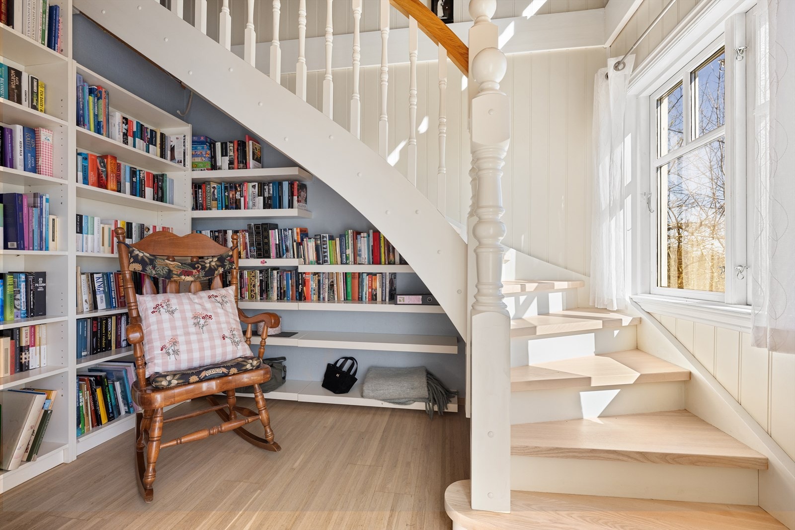 Den malte tretrappen med plassbygde bokhyller leder opp til andre etasje. Galleribilde