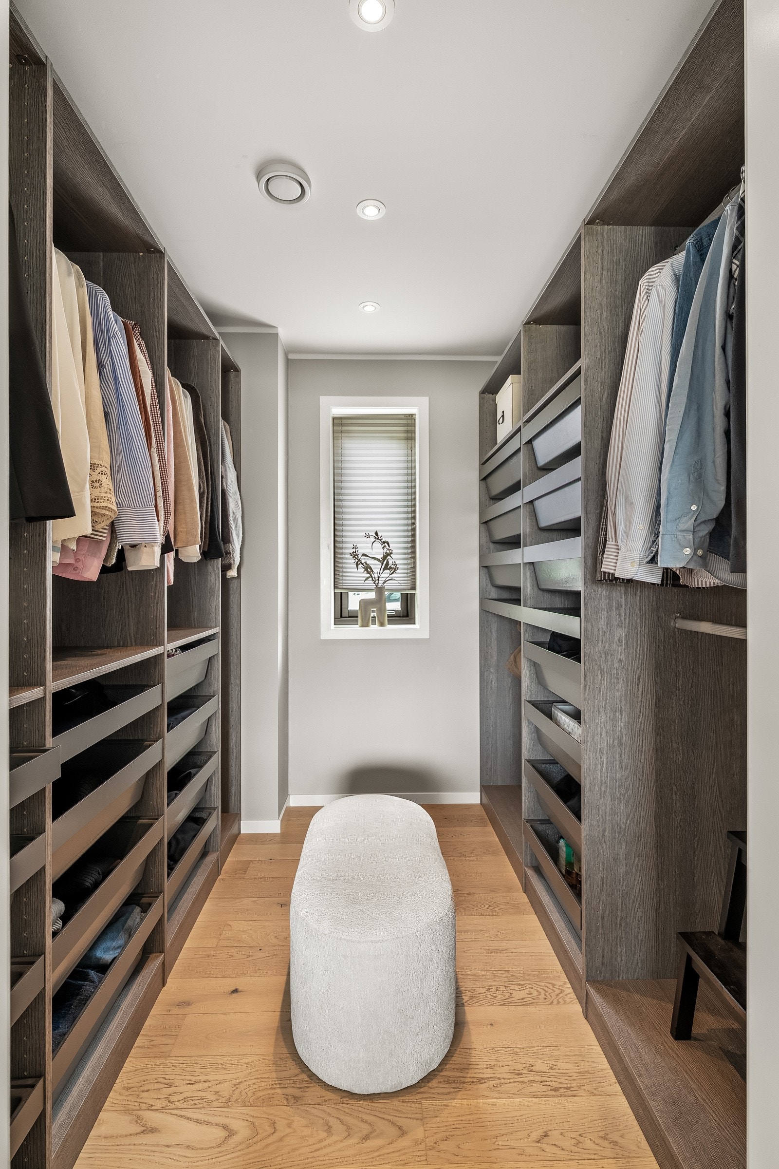 Walk-in closet med god oppbevaringsplass, innredet med hyller, skuffer og oppheng for en ryddig garderobeløsning. Galleribilde