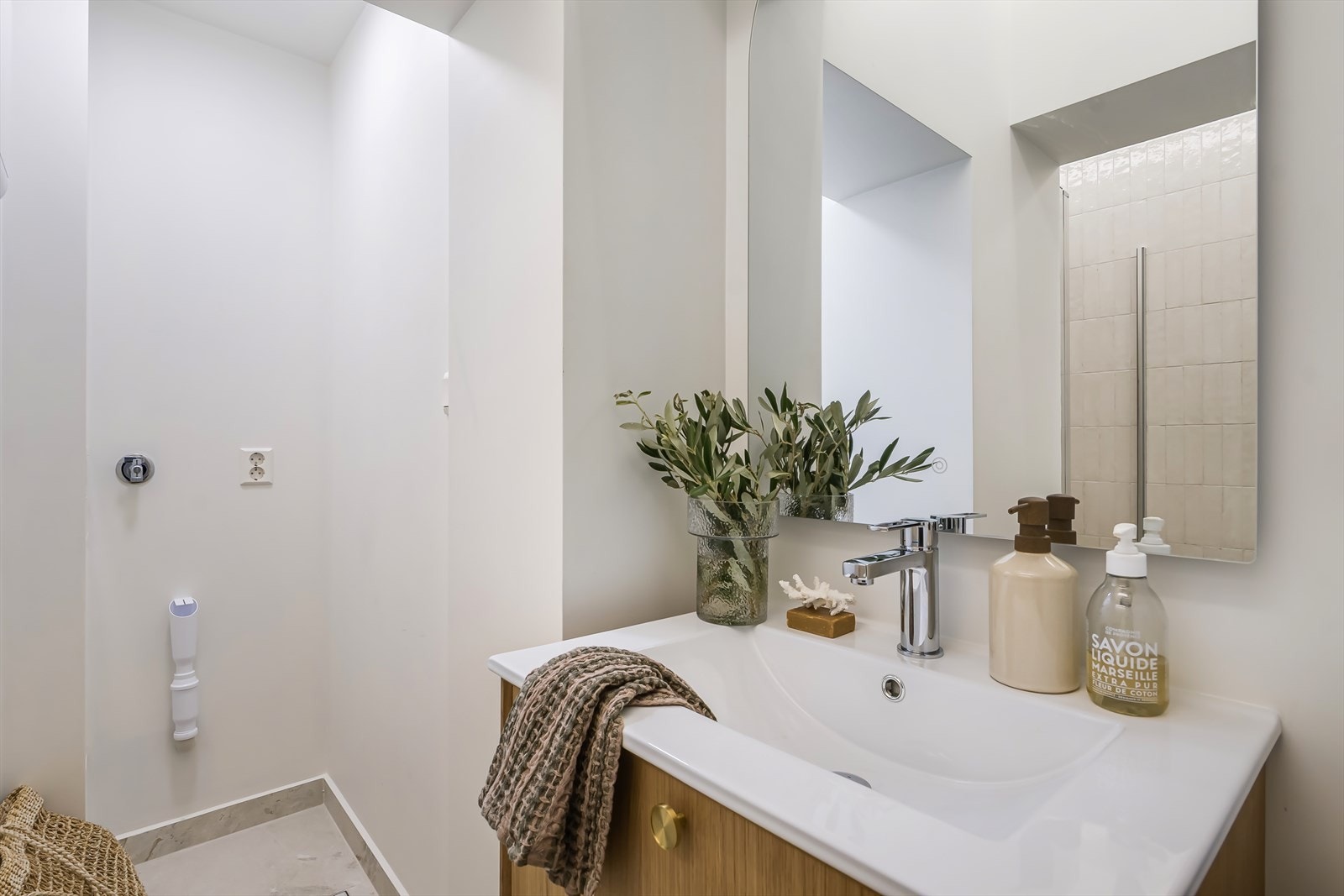 Badet inneholder servantskap, ettgreps armatur fra Tapwell, dusjnisje med innfellbare glassdører, veggmontert wc og opplegg for vaskemaskin. Galleribilde
