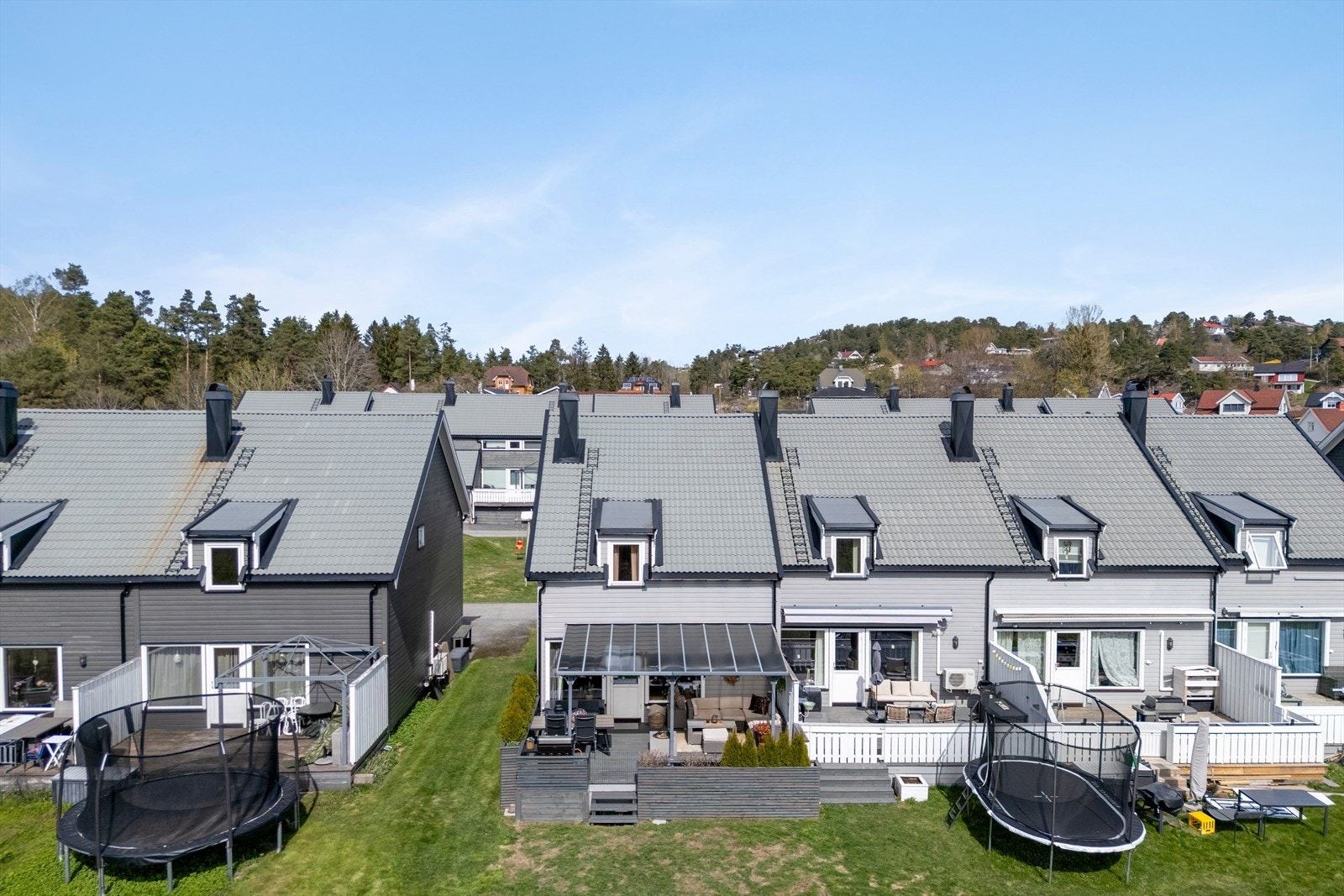 Sameiets utearealer fremstår åpne og grønne mellom boligrekkene. Det finnes også en fellesbod med redskaper som kan benyttes Galleribilde