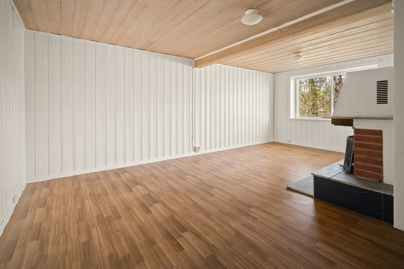 Rommet har laminatgulv og panel på veggene. Galleribilde