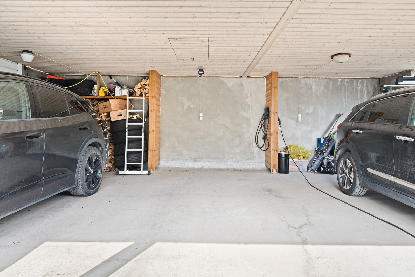 Parkeringsplass i carport like ved boligen. Det er installert ladestasjon for el-bil. Galleribilde