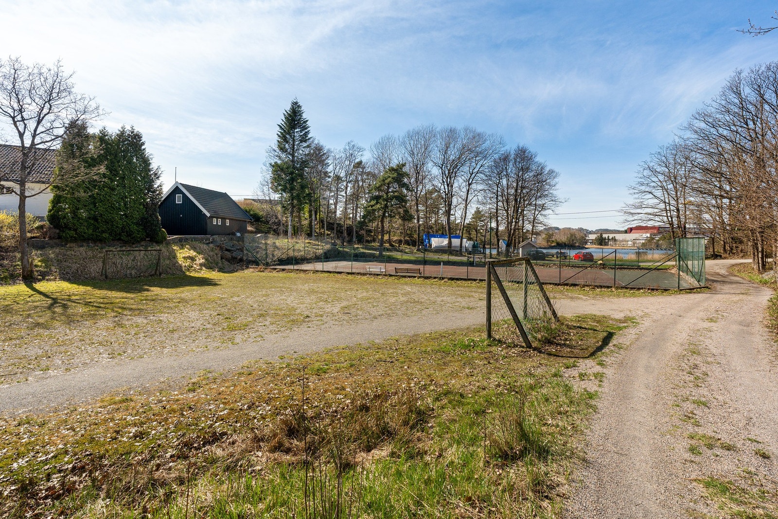 Fra innkjørsel til eiendommen med tennisbane i front Galleribilde