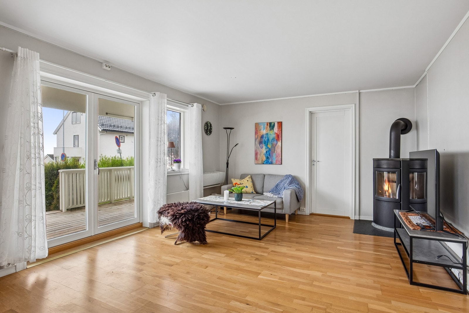 Tofløyet verandadør med store glassfelt setter et luftig preg på rommet. Galleribilde