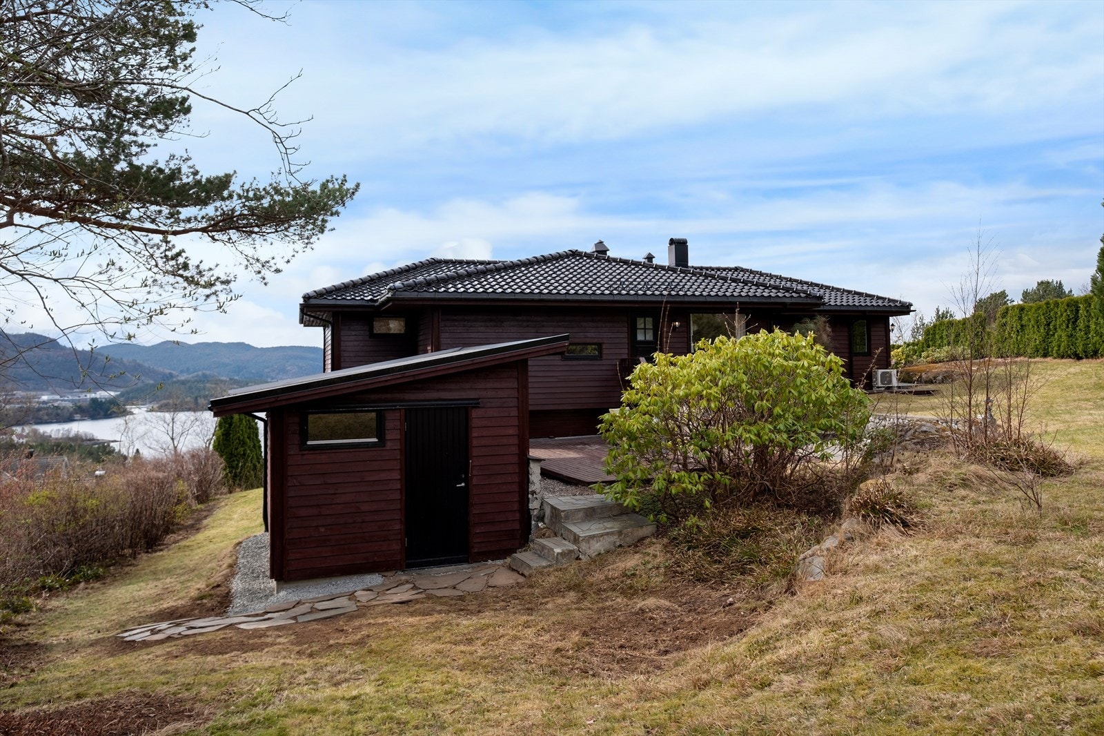 Eiendommen inkluderer en frittstående utebod med adkomst via steintrapp. Galleribilde