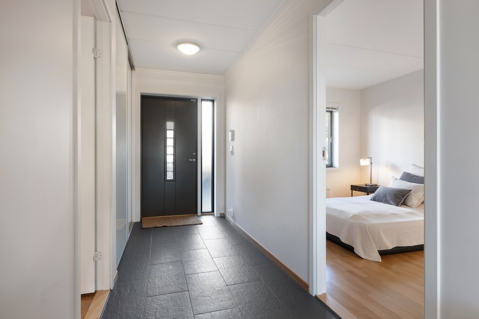 Lys og innbydende entré med god plass for oppbevaring av sko og yttertøy i skyvedørsgarderobe. Galleribilde