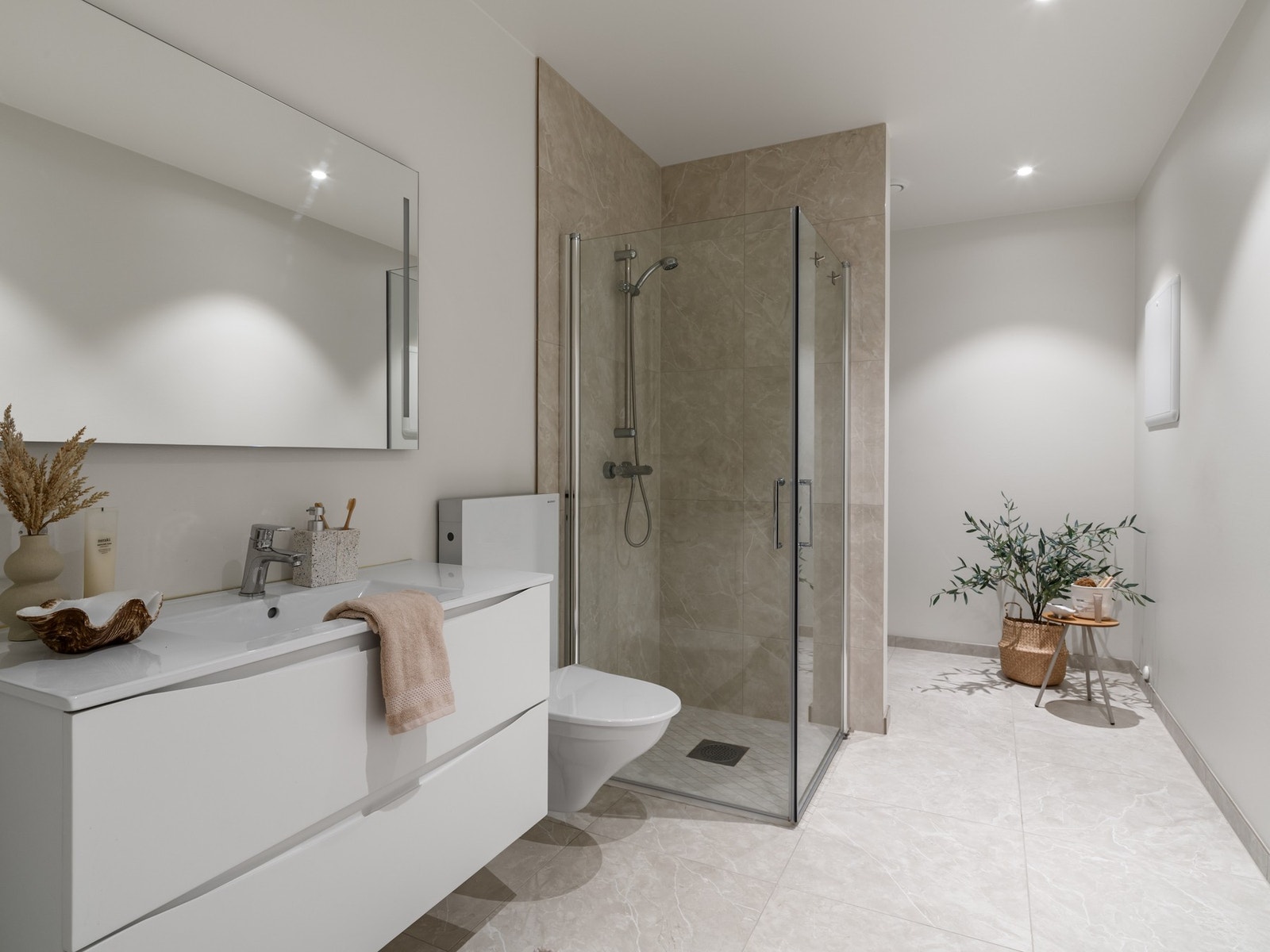 Badet har fliser på gulv og dusjnisje Galleribilde