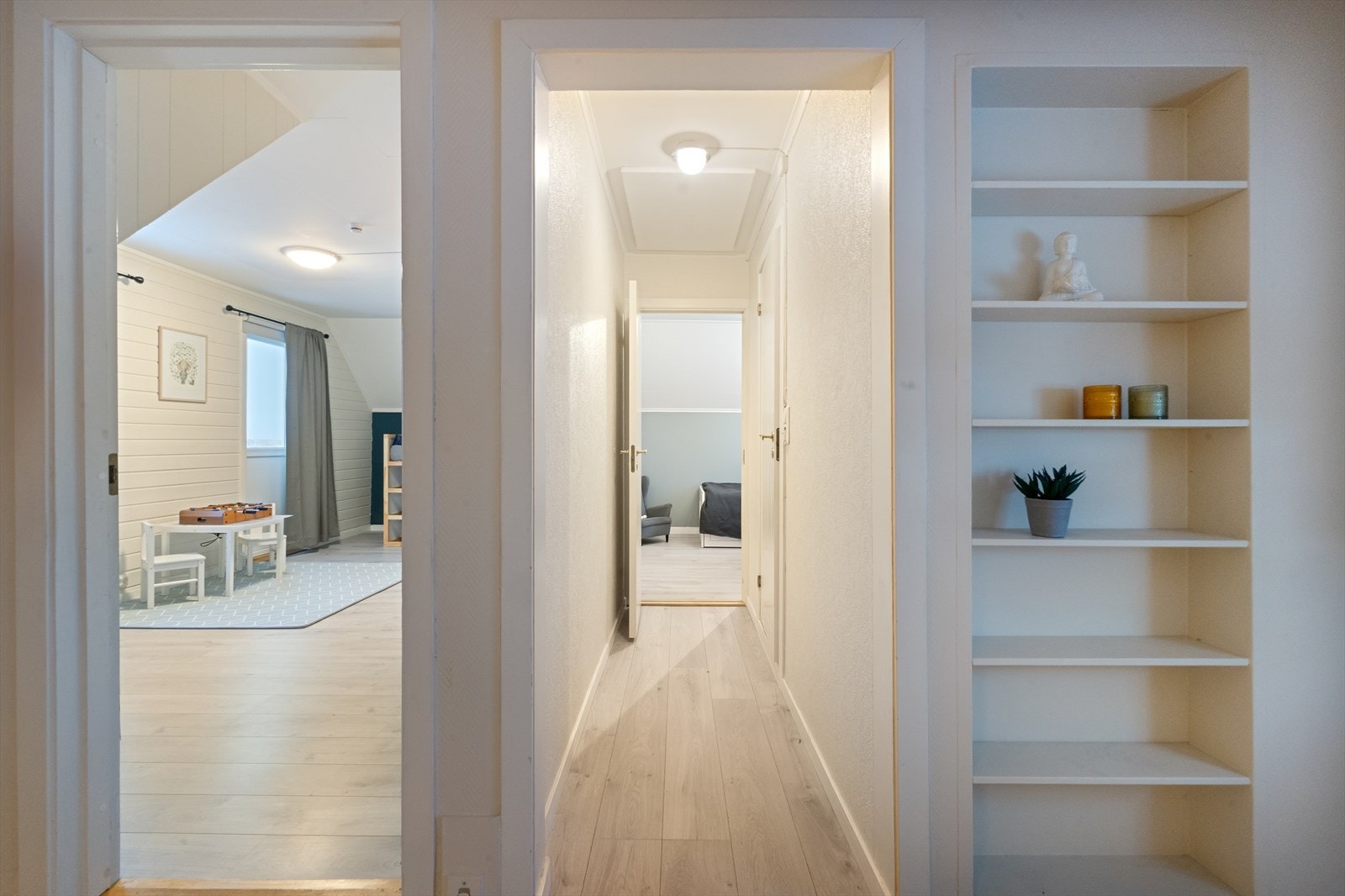Plassbygd hylle ved hall som forbinder ett av soverommene og badet. Det største rommet ligger på venstre hånd på bildet. Galleribilde