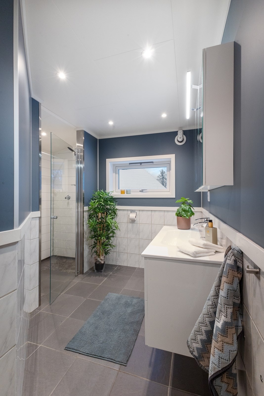 Badet har fliser på gulv og vegger, elektriske varmekabler og moderne innredning. Galleribilde