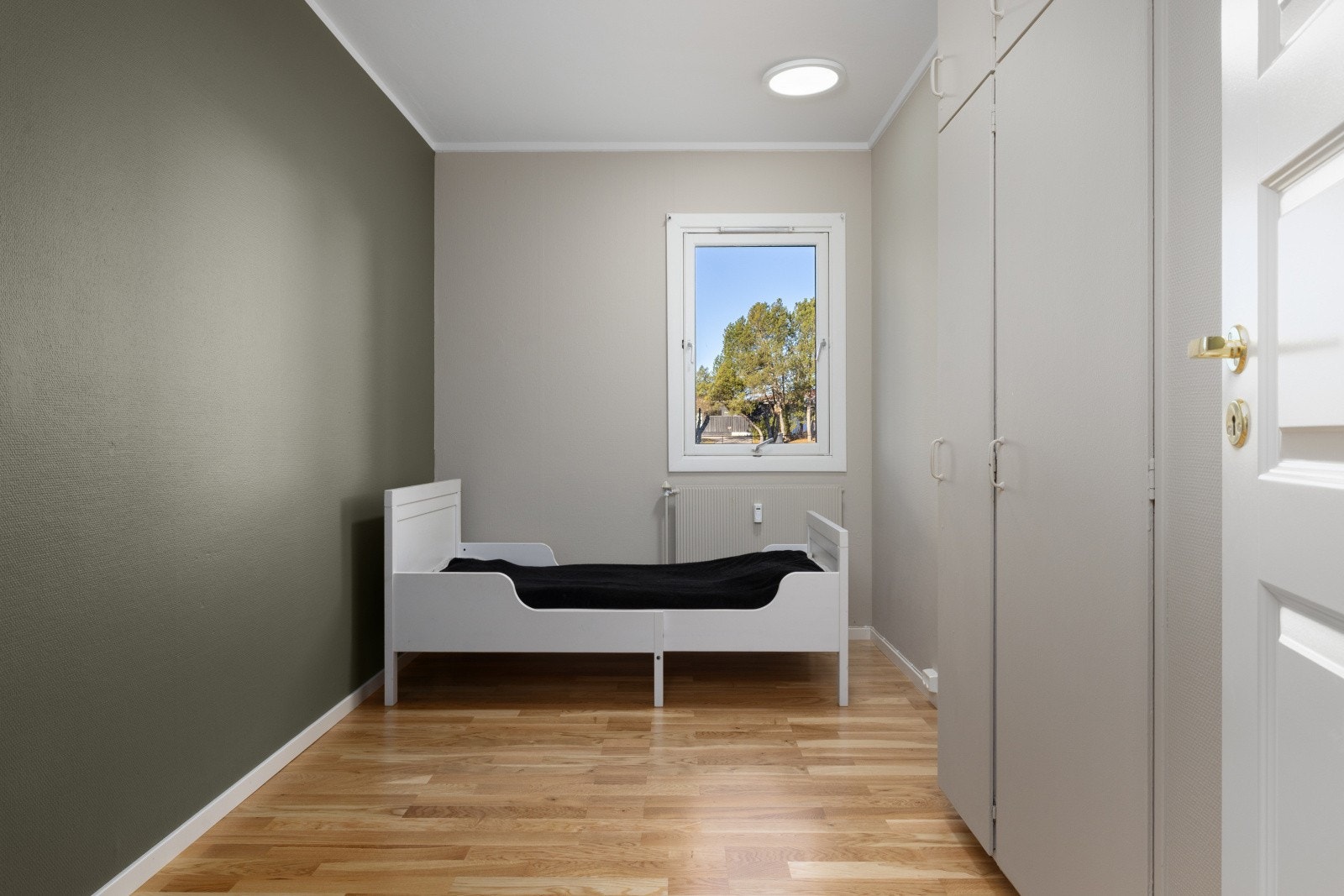 Lyst og funksjonelt soverom med garderobe og plass til enkeltseng. Galleribilde