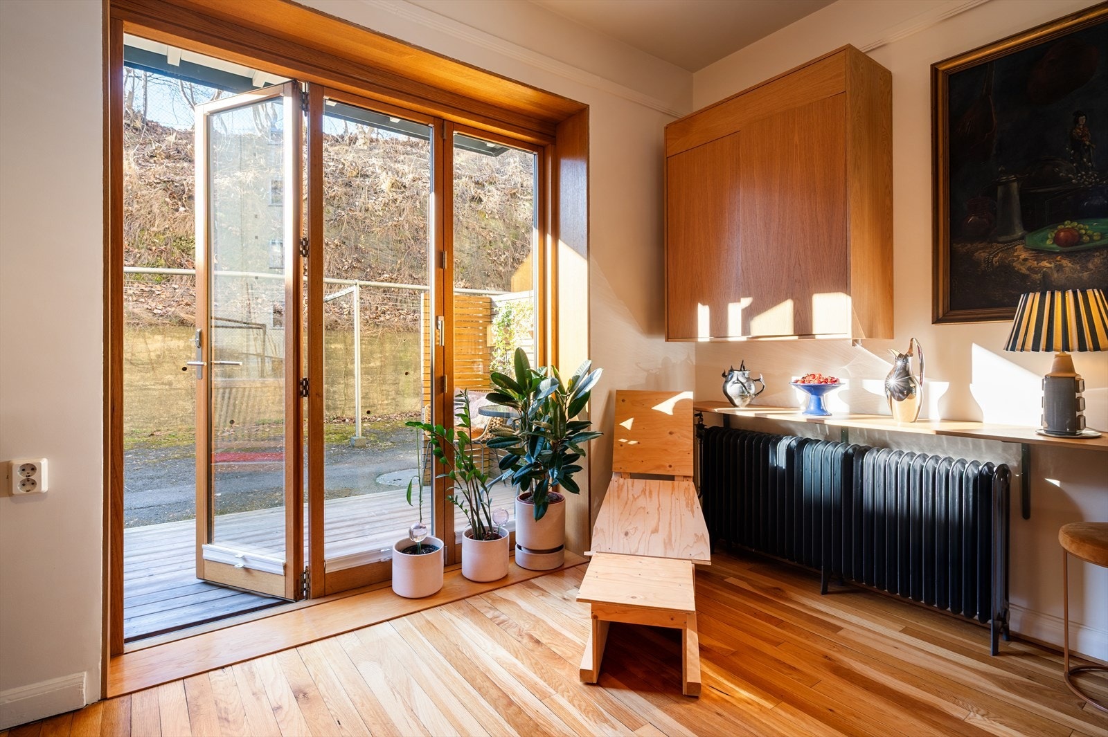 Store glassdører visker ut skillet mellom inne og ute, og leder ut til en trivelig terrasseplatting. Galleribilde