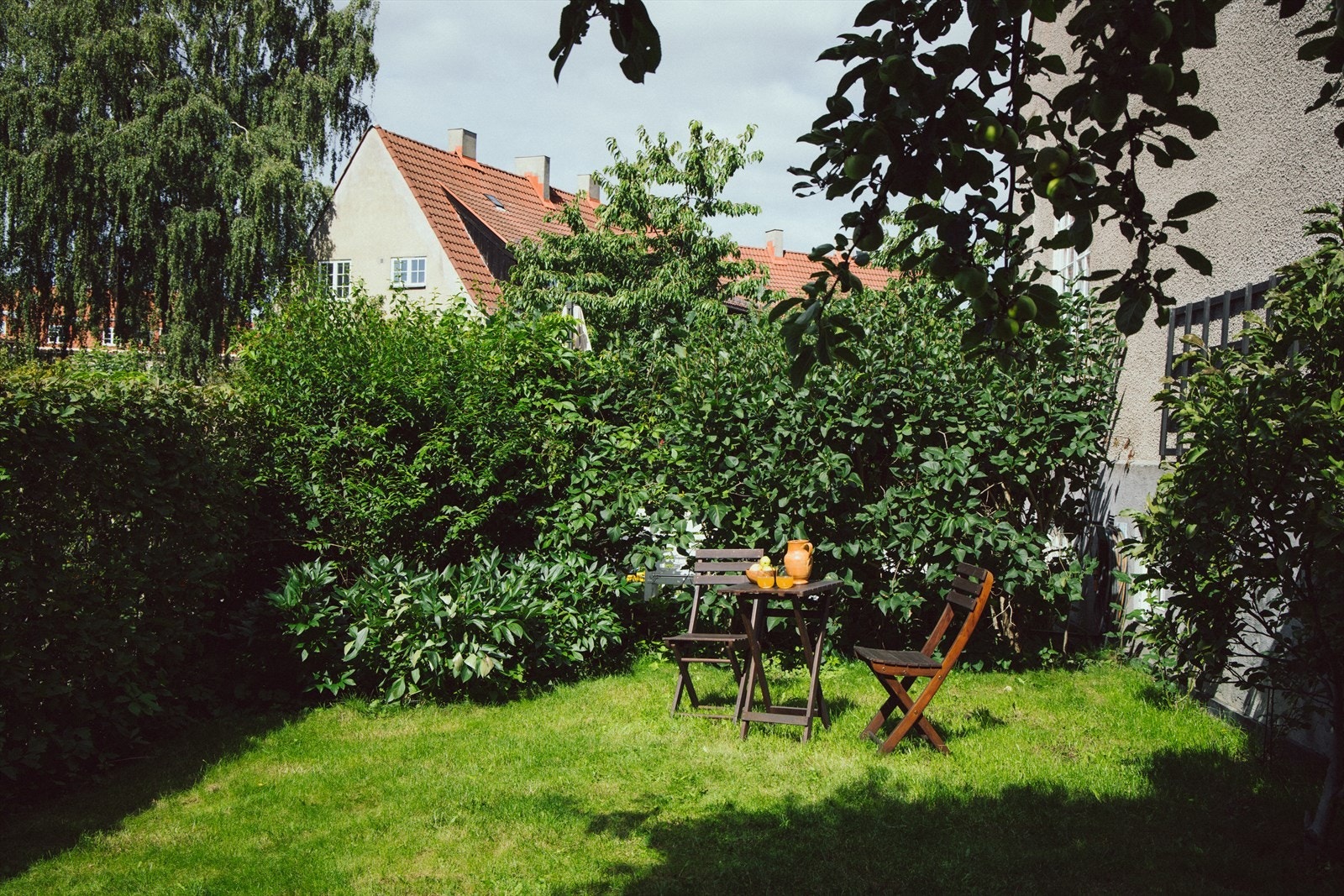 Hagen er pent opparbeidet med gressplen, blomsterbed og busker. Galleribilde