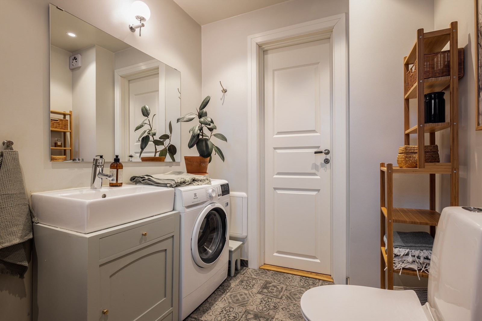 Badet er innredet med toalett, nedfelt servant, innmurt badekar og opplegg for vaskemaskin. Galleribilde