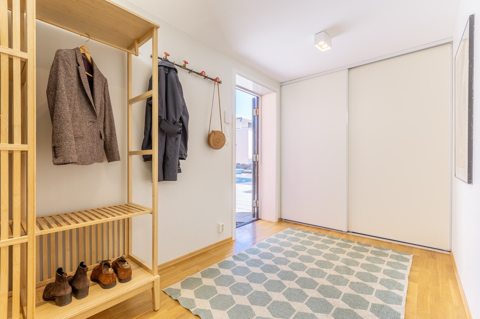 Stor entré med praktisk skyvedørsgarderobe og knaggrekke som gir gode muligheter til ytterklær og sko Galleribilde