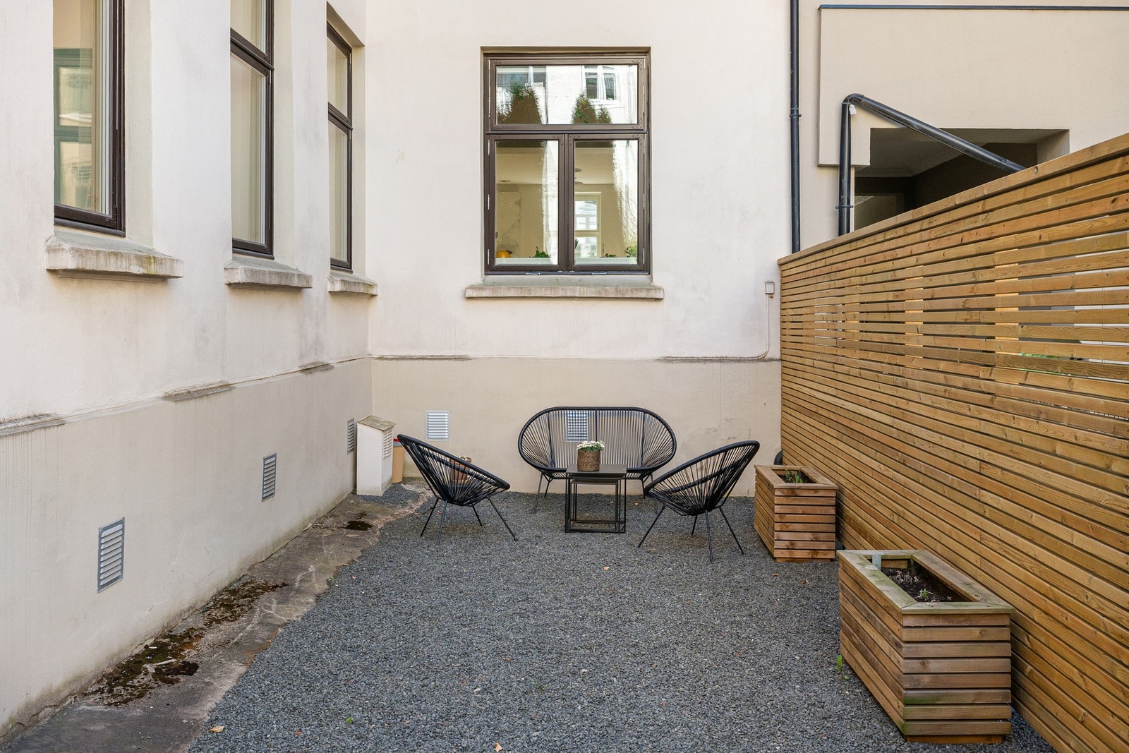 Felles bakgård med singelbelagt uteareal, plantekasser og sittegruppe. Et hyggelig tilskudd til leiligheten, særlig med plasseringen i høy 1. etasje. Galleribilde