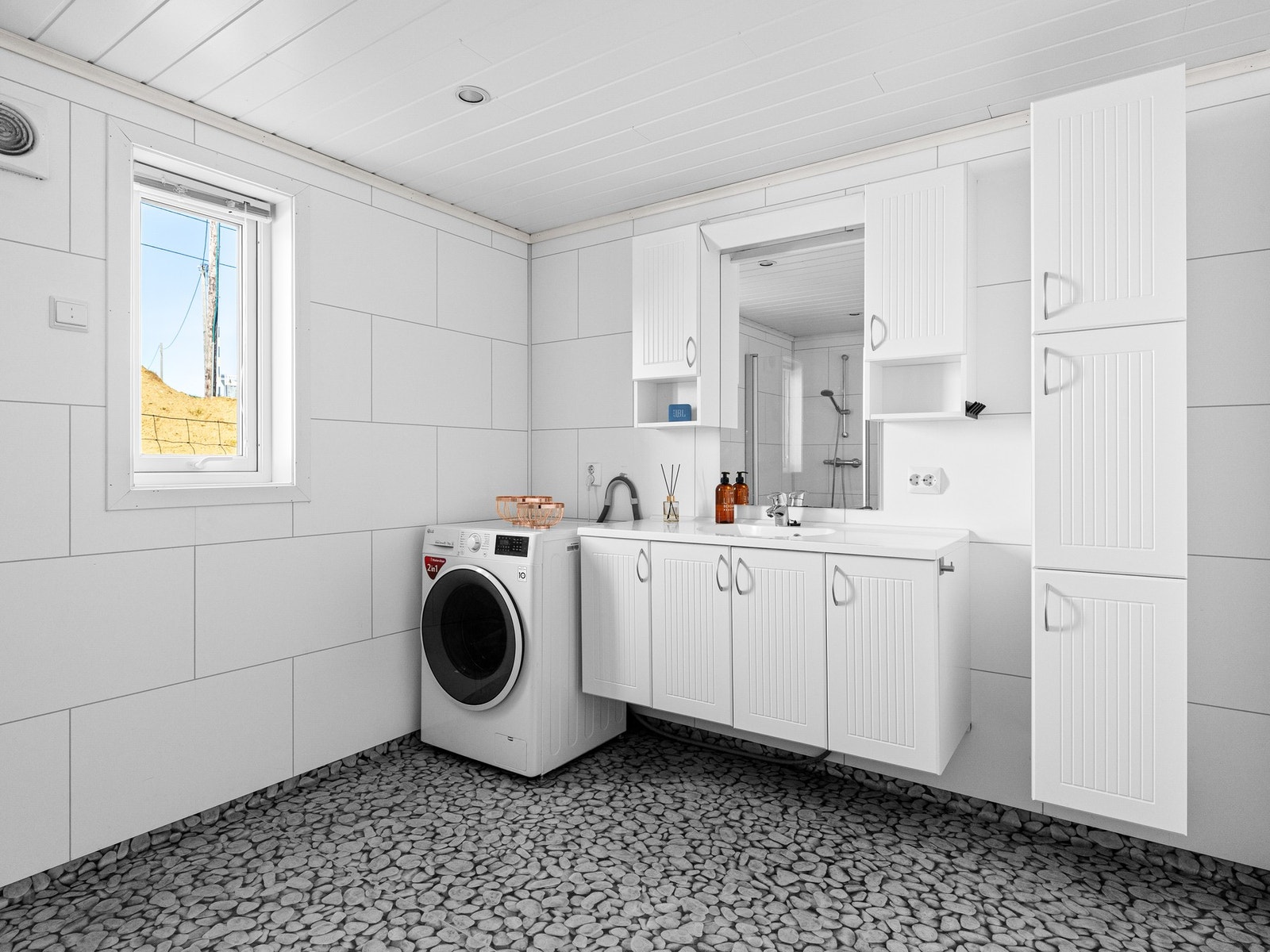 Moderne bad i 1. etasje med lys og praktisk innredning, plass til vaskemaskin, dusj og vegghengt toalett. Galleribilde