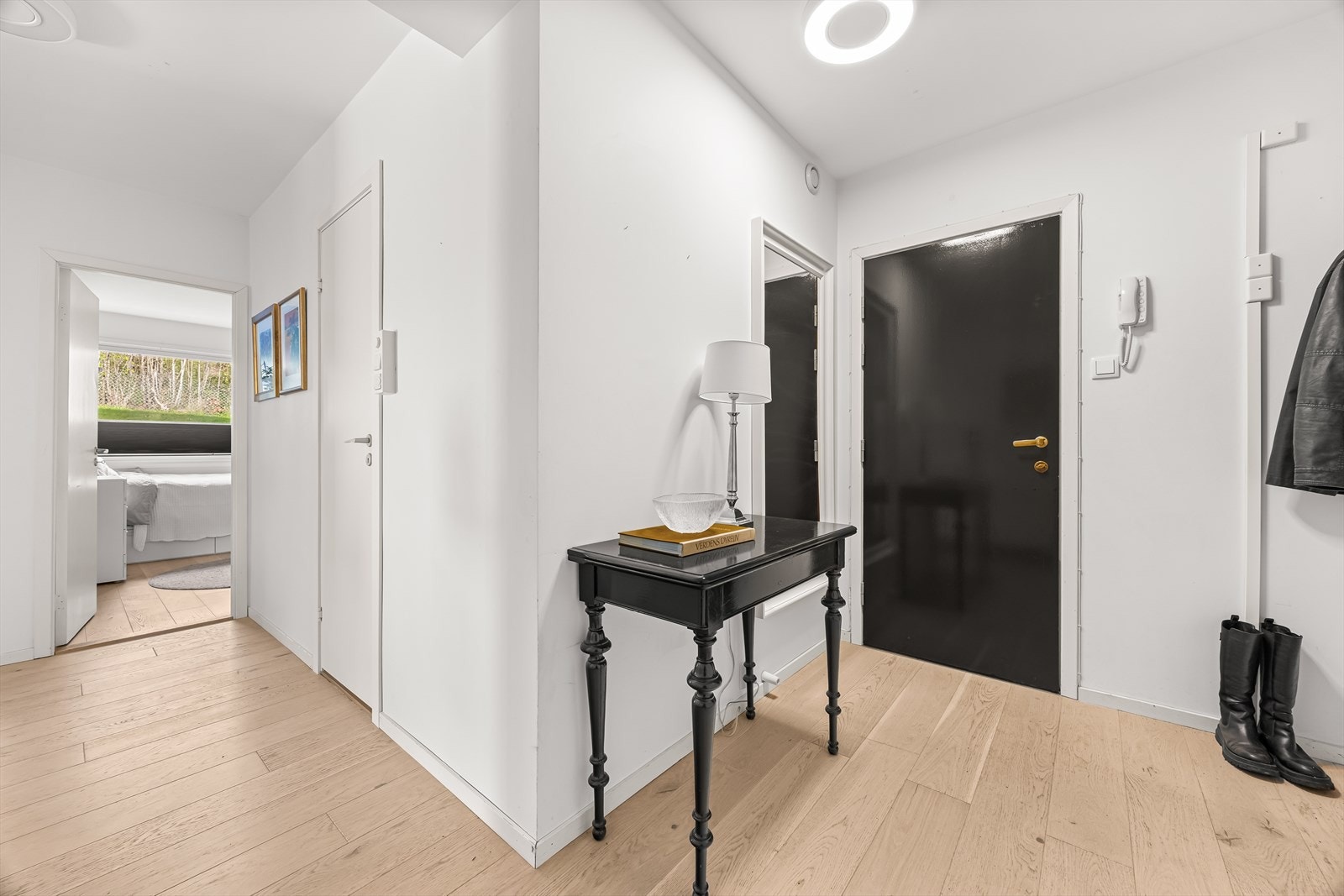 En lys entré med plass til oppheng av yttertøy og oppbevaring av sko. Galleribilde