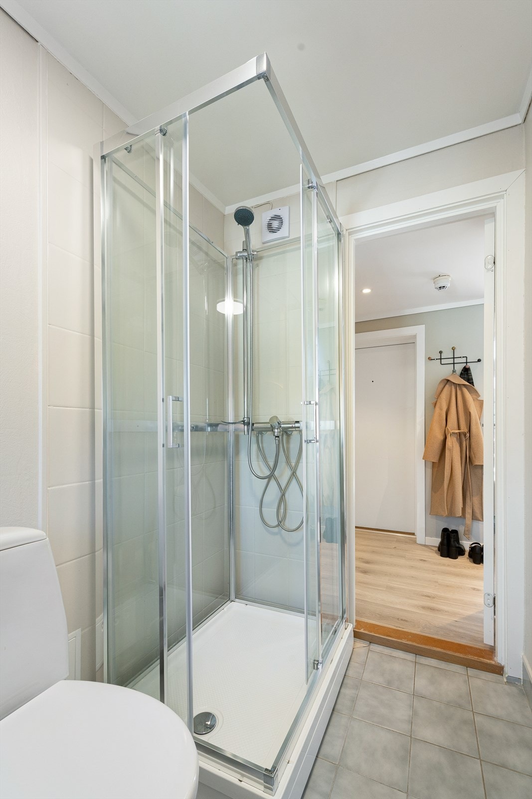 Badet er utstyrt med dusjkabinett og gulvstående toalett. Galleribilde