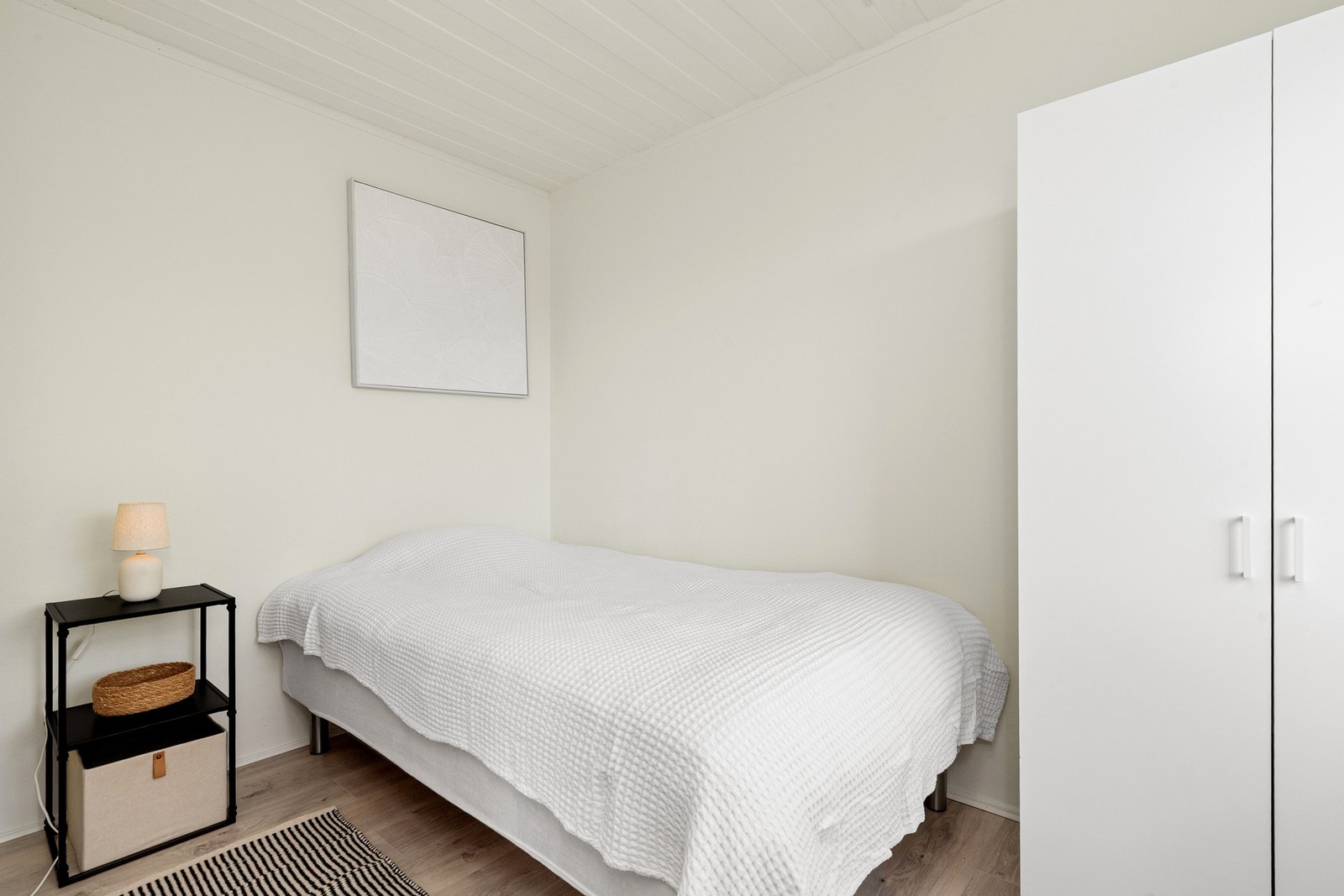 Leiligheten har ett lyst soverom med plass til skaper. Galleribilde