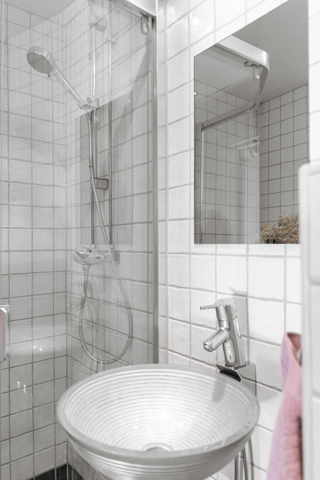 Badet er innredet med servant, vegghengt toalett og dusj med skyvedør Galleribilde
