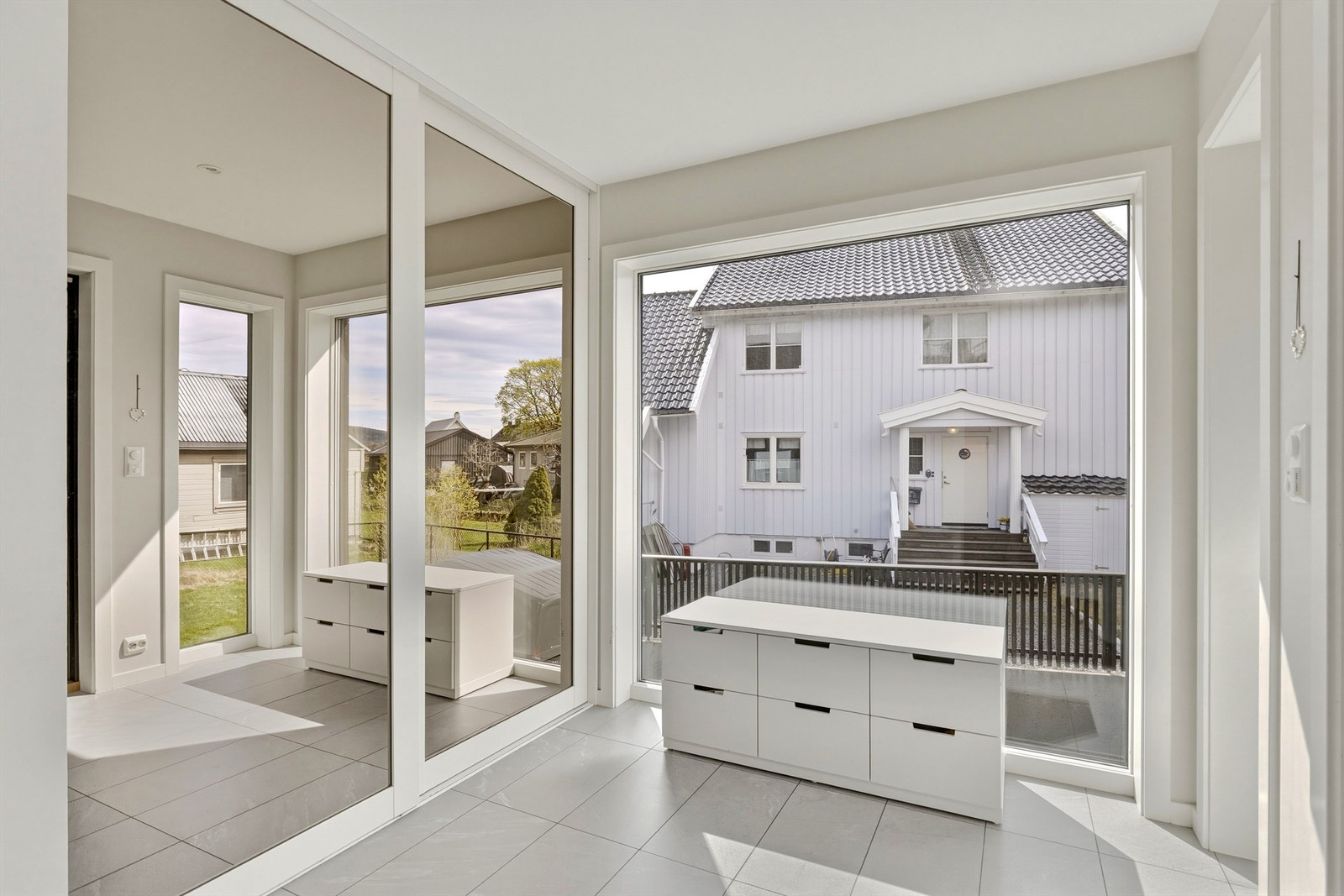 I entréen er det påkledningsplass for hele familien og godt med plass til yttertøy og sko i skyvedørsgarderobe Galleribilde
