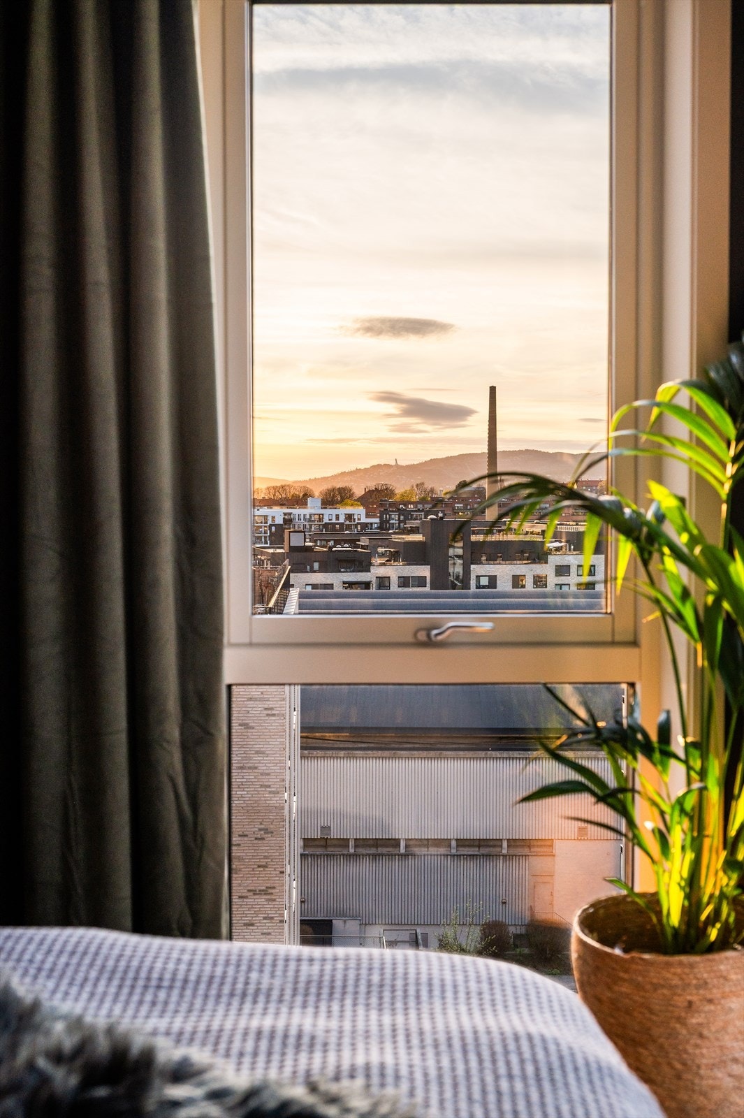 Utsikt fra sengen mot Tryvannstårnet hvor solen går ned på sommeren. Galleribilde