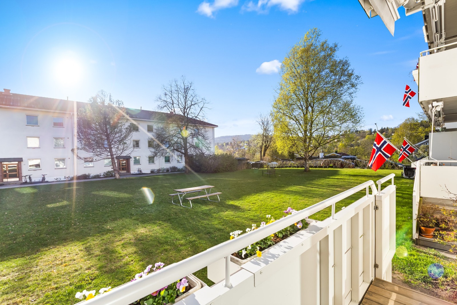 Lukkbar port til trapp og få trinn til hagen. Det er god plass mellom bygningene i borettslaget - slik man bygget i gamle dager ! Galleribilde