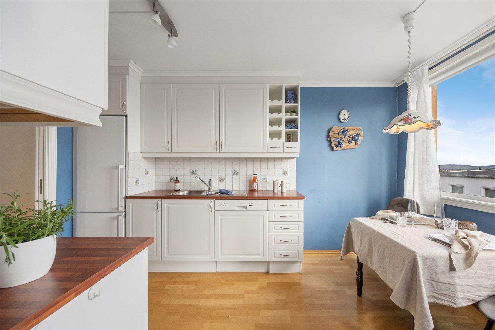 Kjøkkenet har en pen innredning fra byggeår med hvite, profilerte fronter og laminatbenkeplate med nedfelt oppvaskkum i stål. Det gjøres oppmerksom på at kjøkkenkranen er defekt og lekker. Galleribilde