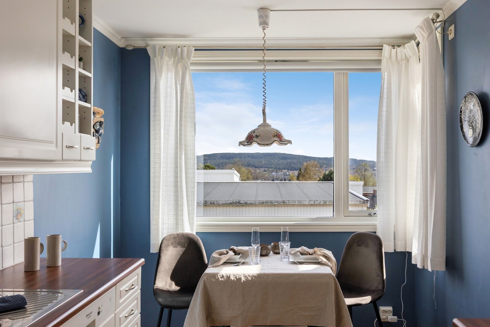 Det store vinduet på kjøkkenet er utstyrt med en praktisk, elektrisk screen for solskjerming. Galleribilde
