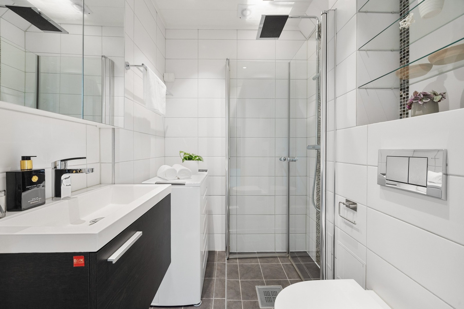 Det er opplegg til vaskemaskin på badet. Praktiske oppbevaringshyller over toalettet. Galleribilde