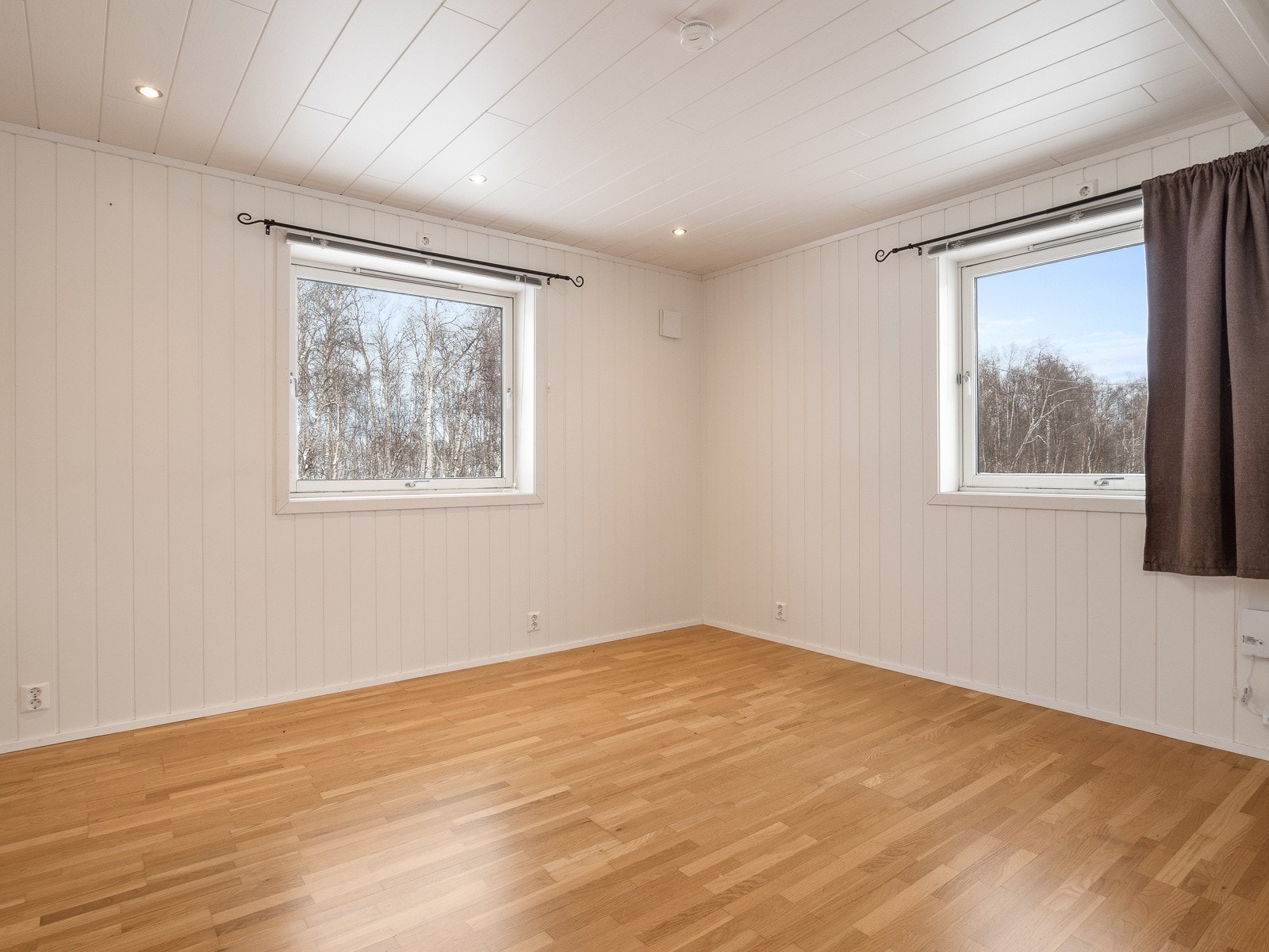 Stuen har vinduer i to himmelretninger, og det er spotbelysning i taket Galleribilde