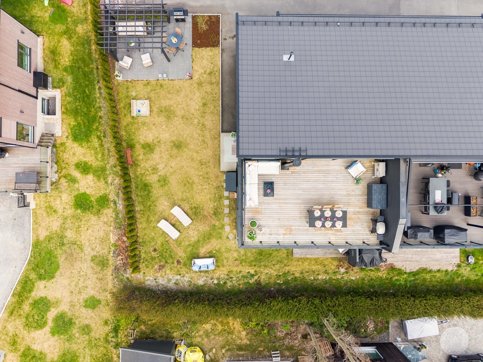 Oversiktsbilde som viser hagen med pergola og takterrassen. Fellesarealet er delt mellom boenhetene med avtale ekslusiv bruksrett. Galleribilde