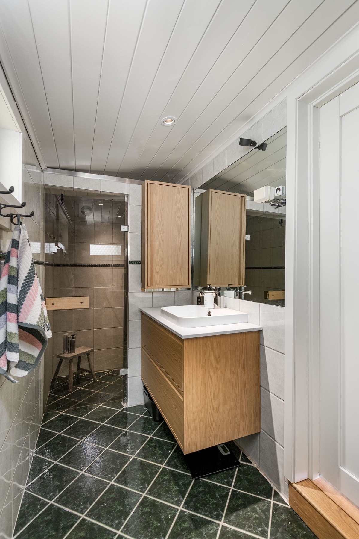 Eldre, flislagt bad fra med varme i gulv. Lysmalt panelt himling med downlights. Galleribilde