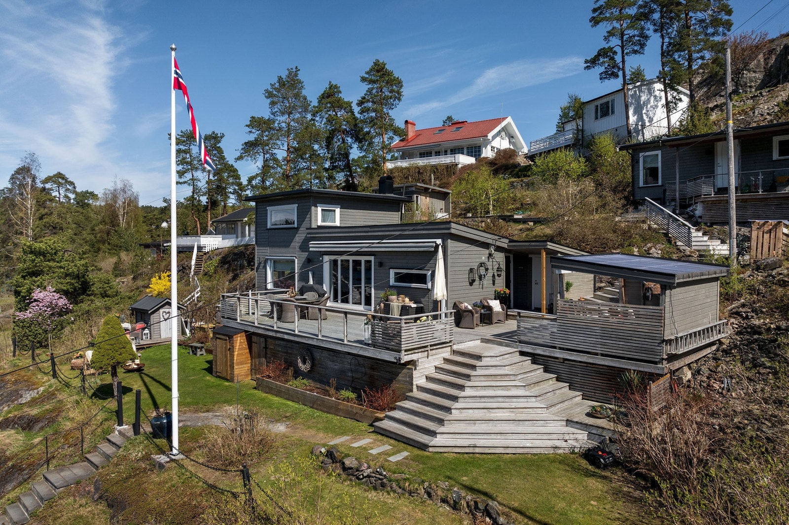 En pent opparbeidet hage og uteplass med flere soner byr opp til lange dager utendørs for familien i flotte omgivelser Galleribilde