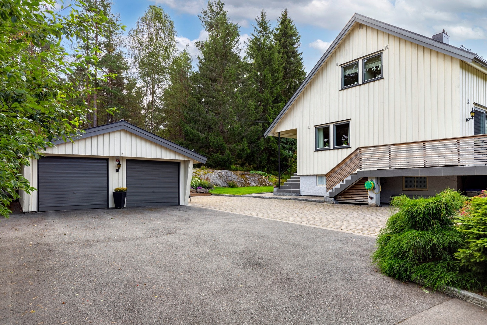 Det er parkering i dobbelgarasje med vippeporter med åpner og på asfaltert gårdsplass med plass til flere biler. Galleribilde