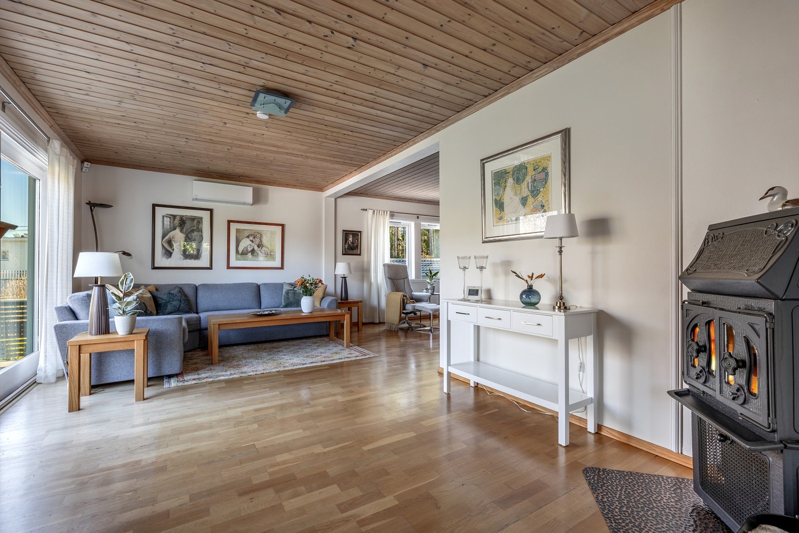 En stemningsfull peisovn bidrar til både varme og en lun atmosfære, og gjør stuen til et naturlig samlingspunkt gjennom hele året. Galleribilde