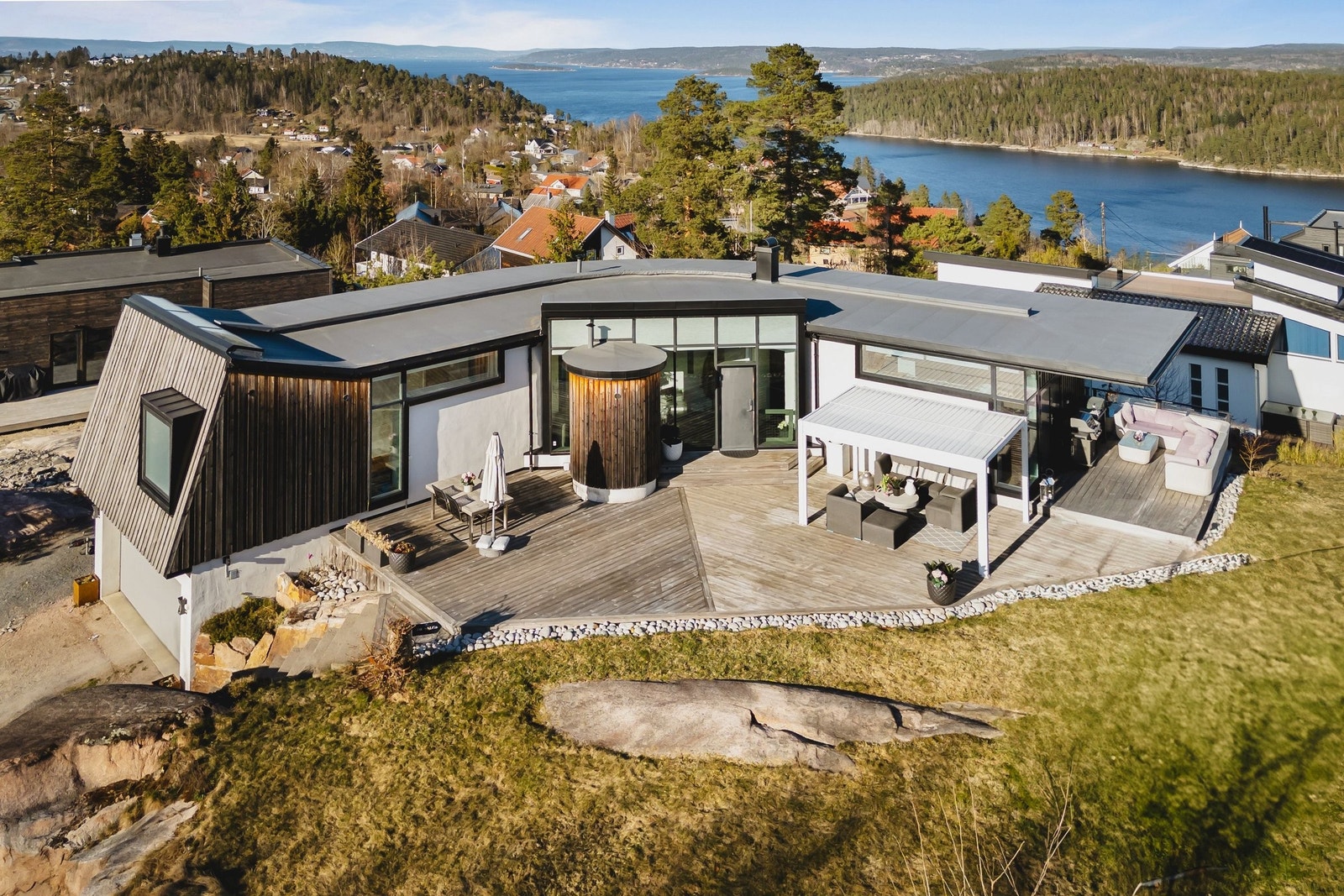 Huset er boomerang-formet, med et svevende tak i den ene enden og skrå tak og skrå vegg i den andre enden. Det er flere fine solfylt uteplasser Galleribilde