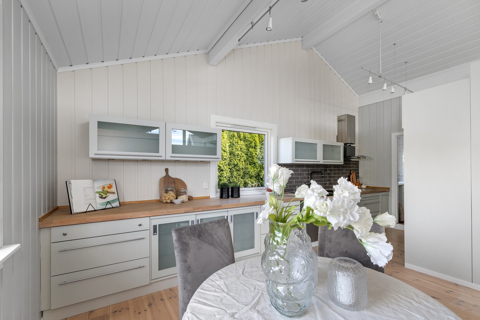 Plassbygget kjøkken fra Elen Møbelstudio med slette fronter hvorav noen med glassfelt. Galleribilde