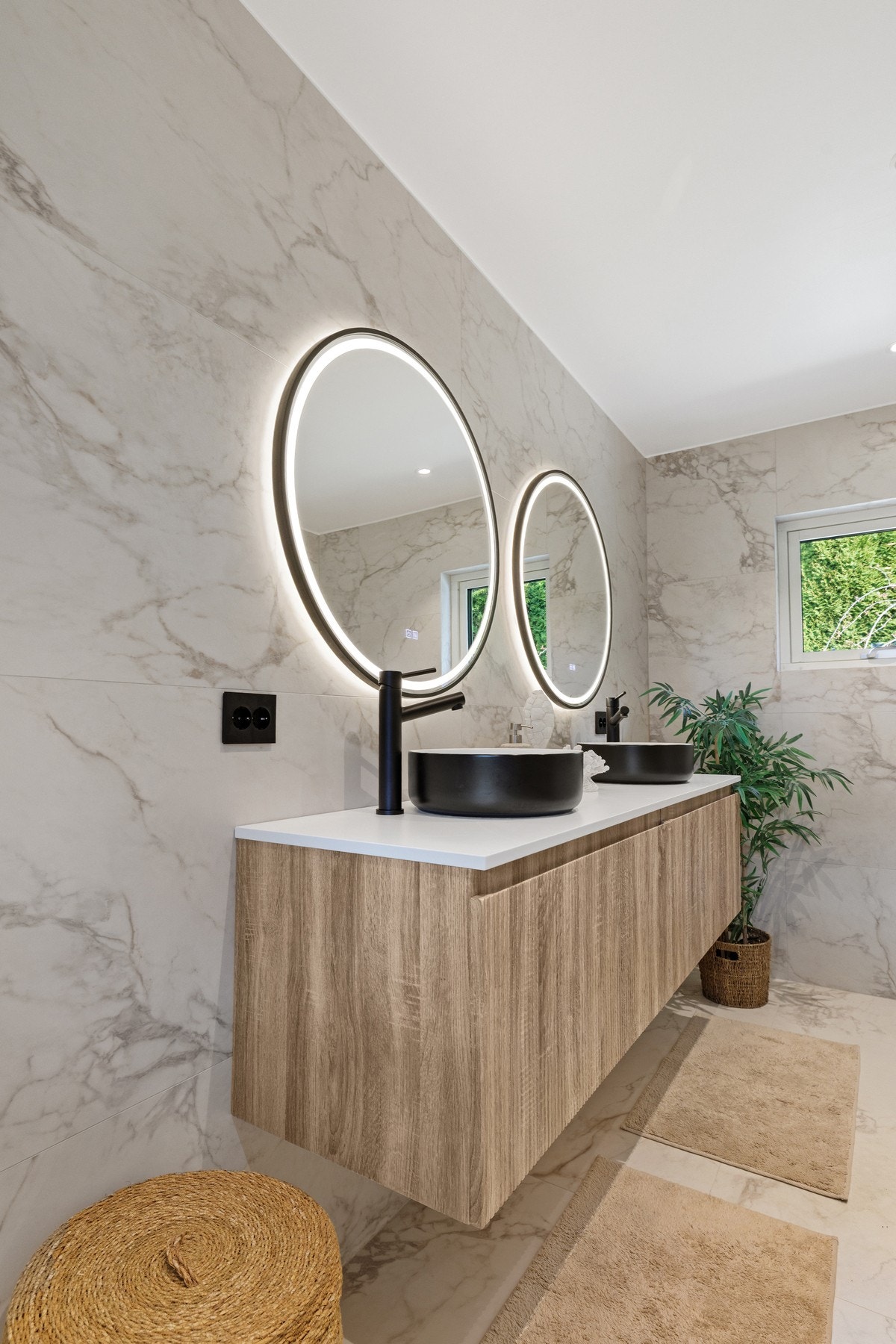 Badet er innredet med to ovenpåliggende servanter på underskuffer, to speil med integrert belysning og vegghengt toalett. Galleribilde