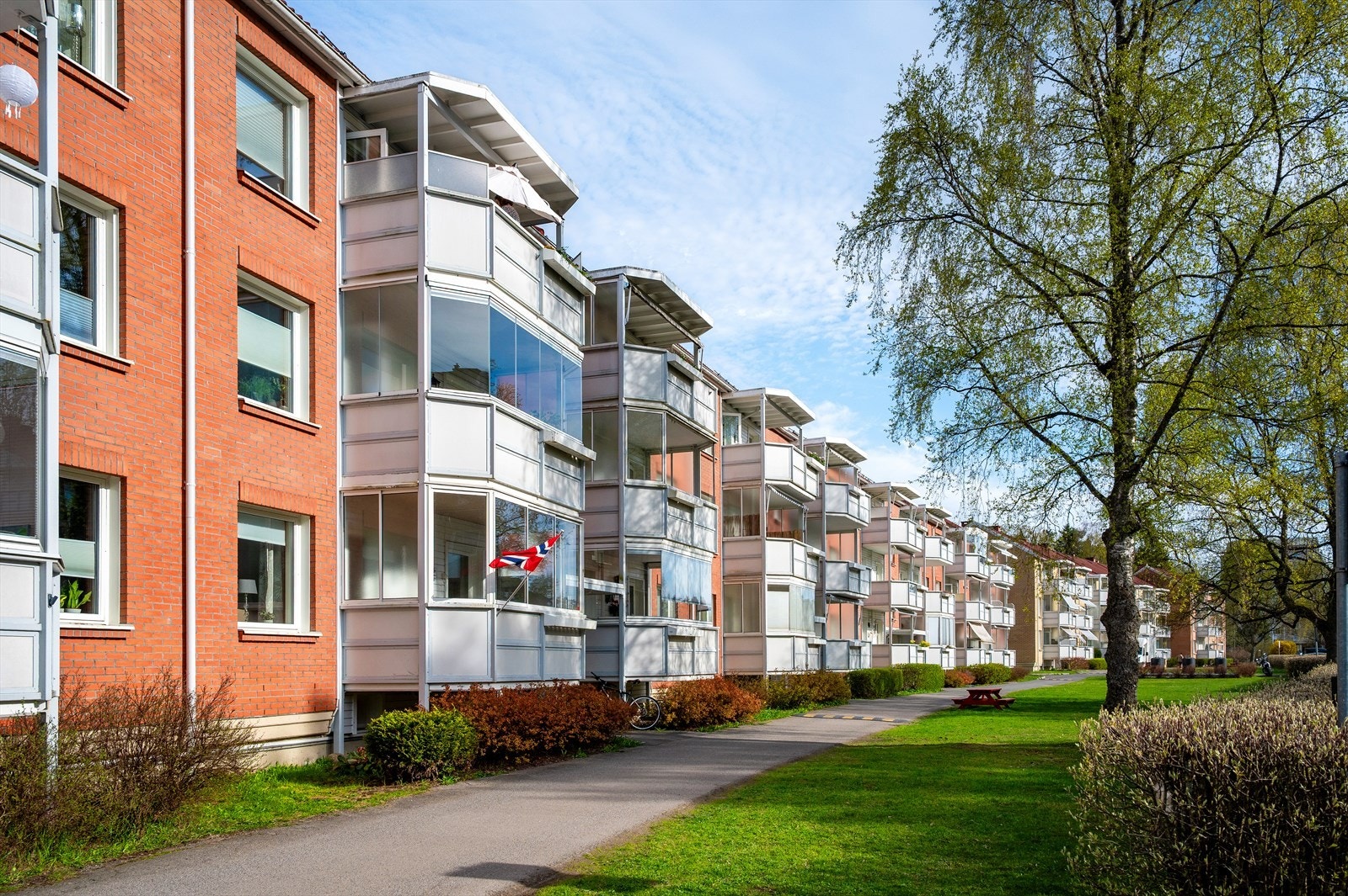 Tomten er pent opparbeidet med asfalterte internveier, grøntområder, beplantning, benker og lekeapparater. Galleribilde