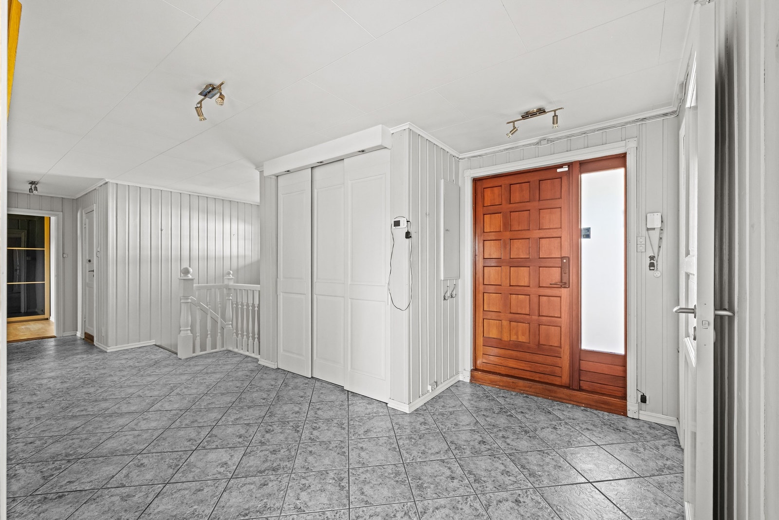 Entréen har flislagt gulv og en stor skyvedørsgarderobe for effektiv oppbevaring. Galleribilde
