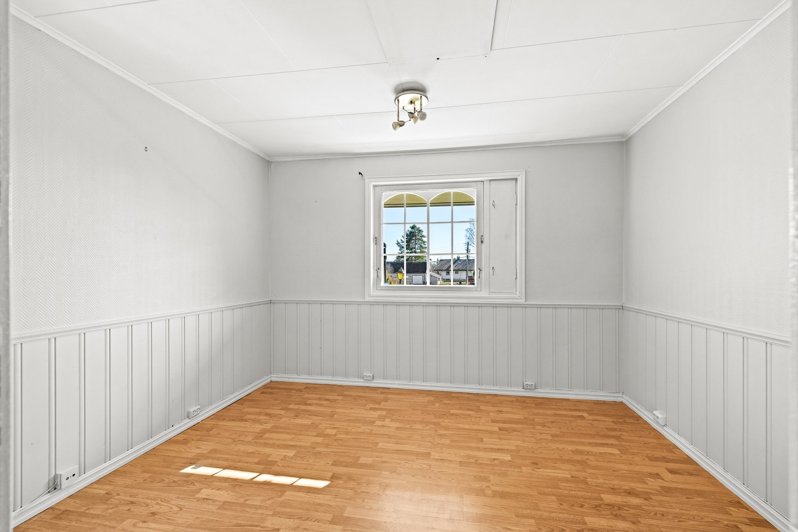 Et av boligens tre soverom i første etasje. Rommet har laminat på gulvet og vegger med malt strietapet og panel. Galleribilde