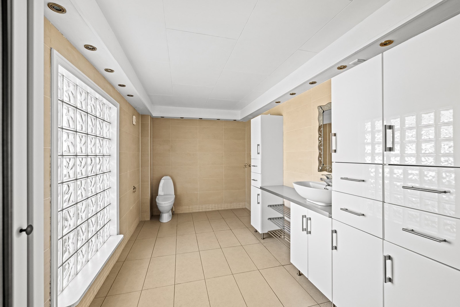 Badet har rikelig med skapplass, downlights i taket og opplegg for vaskemaskin. Galleribilde