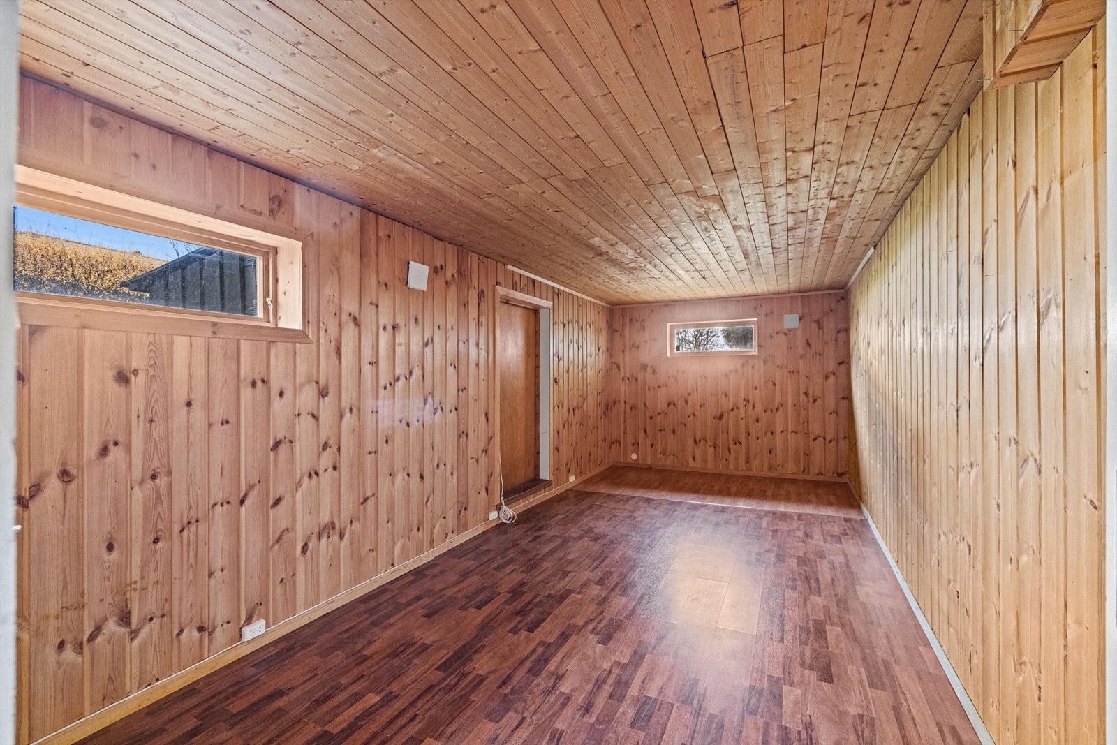 Kjellerrom med panel på vegger og i himling og egen utgang/inngang. Galleribilde