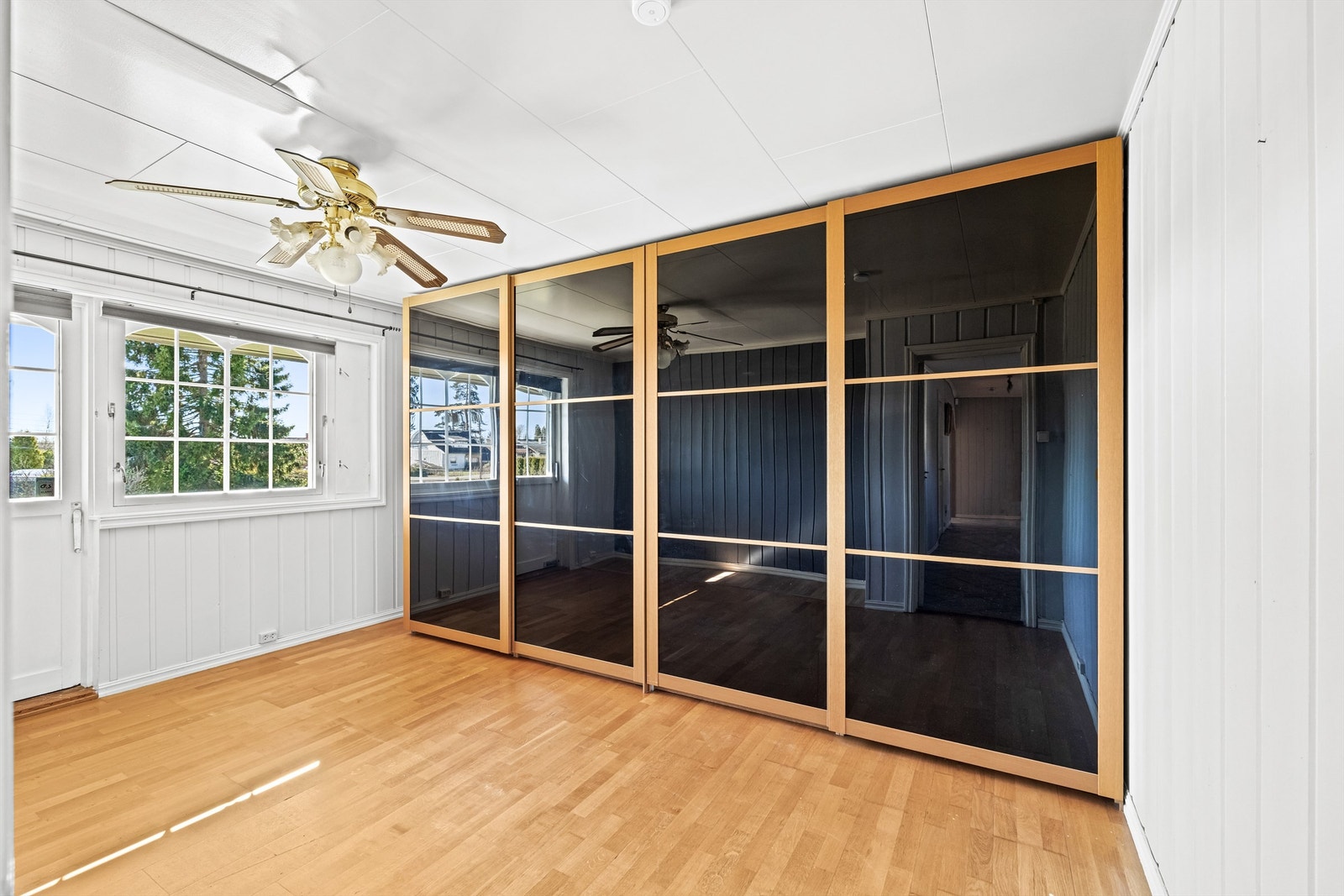 Hovedsoverommet har en romslig skyvedørsgarderobe med mørke glassfronter. Galleribilde