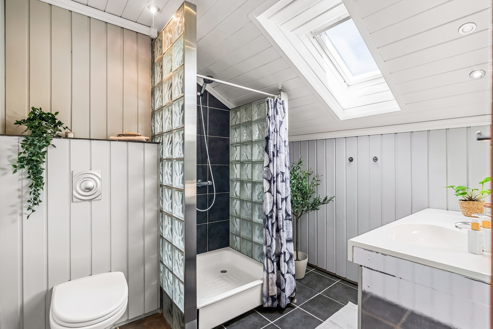 Det er fliser på gulvet, samt trepanel på vegger og himling. Badets innredning består av skap med profilerte fronter, i tillegg til servant, klosett, kabinett. Også dette badet har mekanisk avtrekk. Galleribilde
