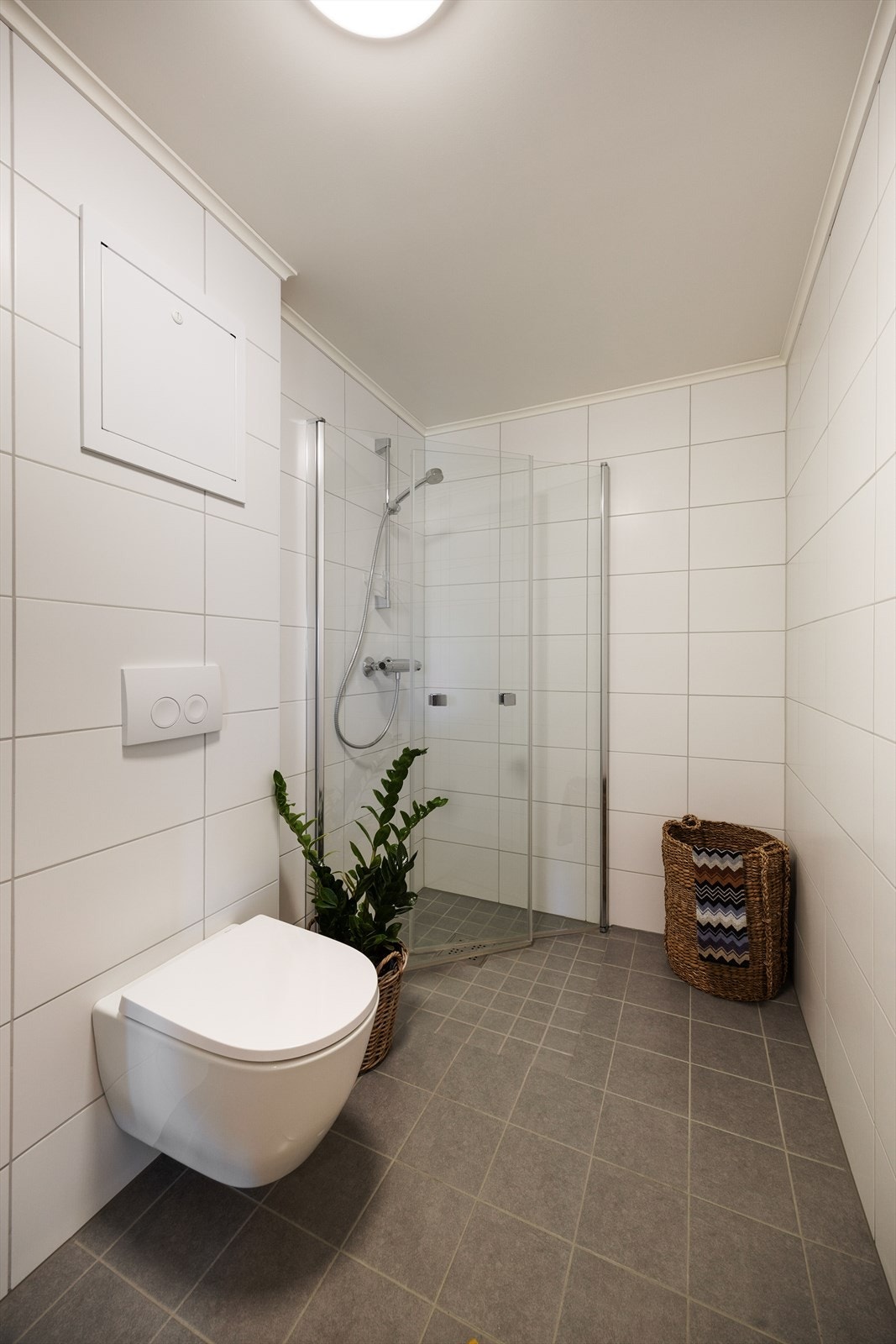 Badet ble oppgradert nytt i 2025 av borettslaget og har flislagte vegger og gulv med elektriske varmekabler, samt veggmontert toalett og dusjhjørne. Galleribilde