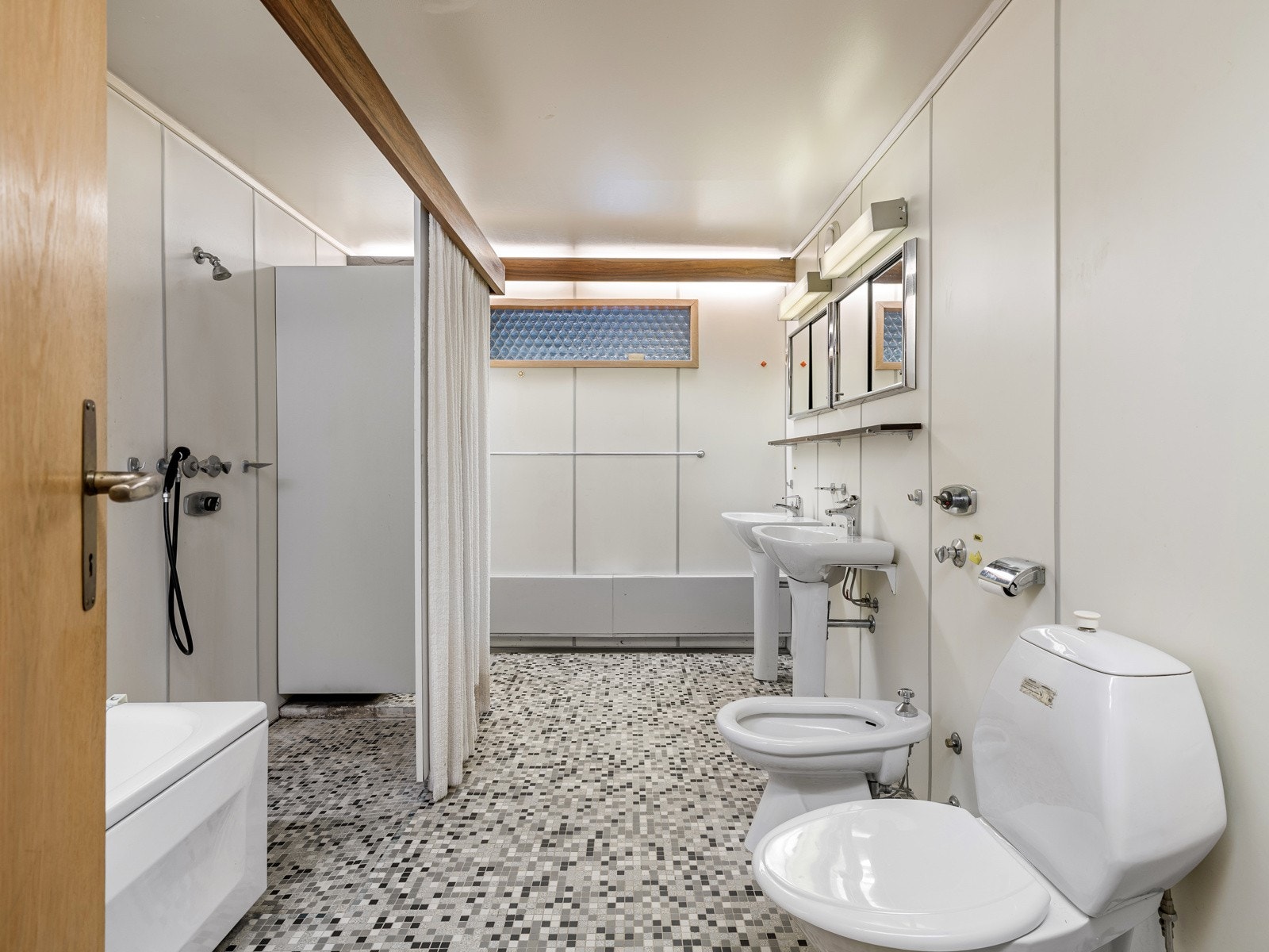 Badet i underetasjen har fliser og betong på gulv. Vegger har høytrykkslaminerte plater. Galleribilde